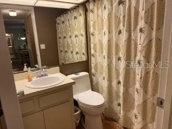 a bathroom with a toilet sink shower and mirror
