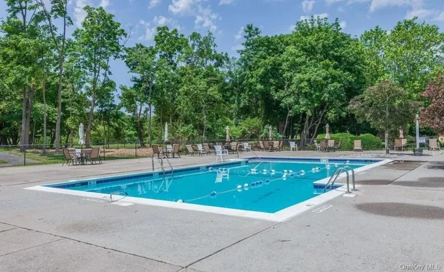 a swimming pool with outdoor seating and lake