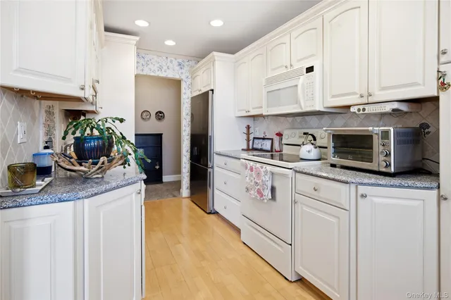 a kitchen with cabinets and wooden floor