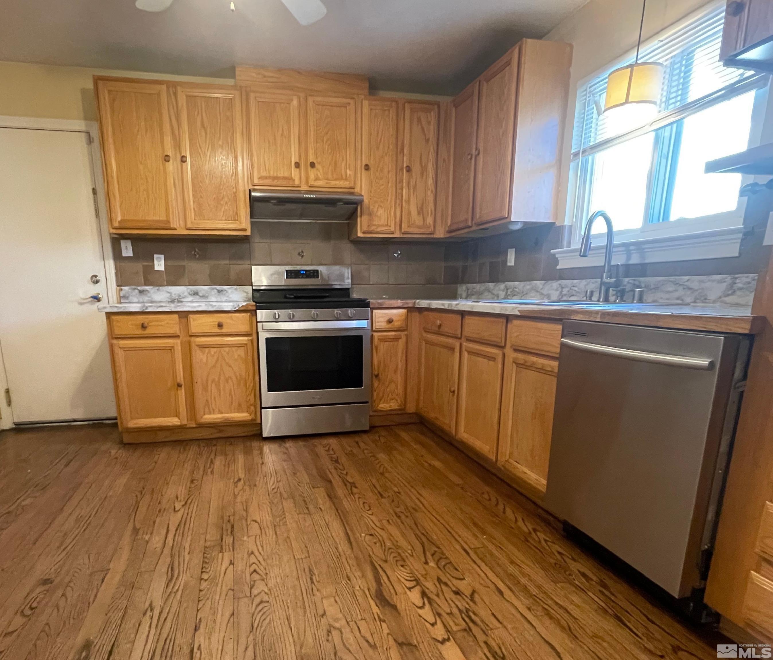 4500 Aster Drive Reno, NV 89502 - Photo 3 of 10 a kitchen with granite countertop wooden floors and stainless steel appliances