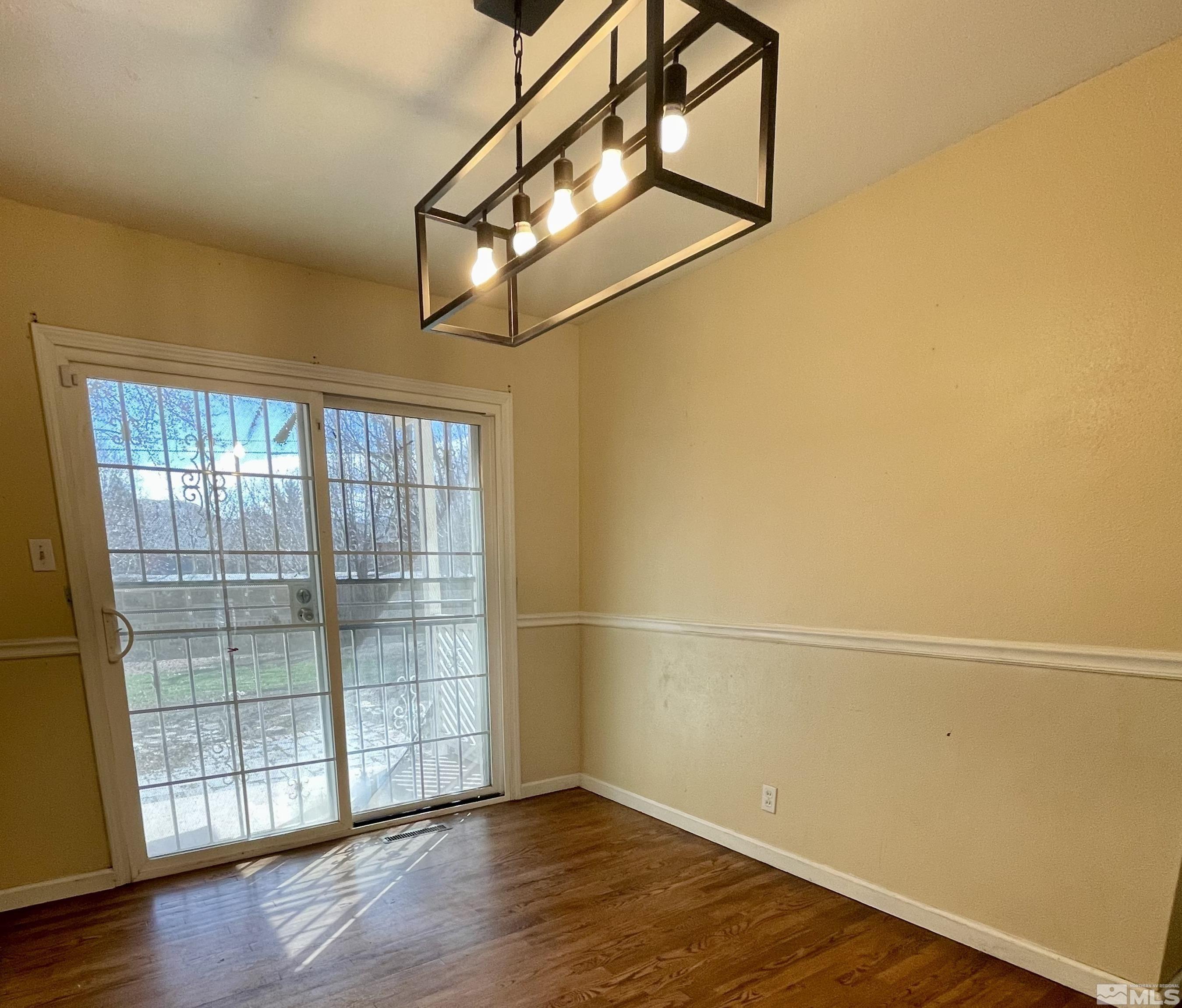 4500 Aster Drive Reno, NV 89502 - Photo 4 of 10 an empty room with wooden floor and windows