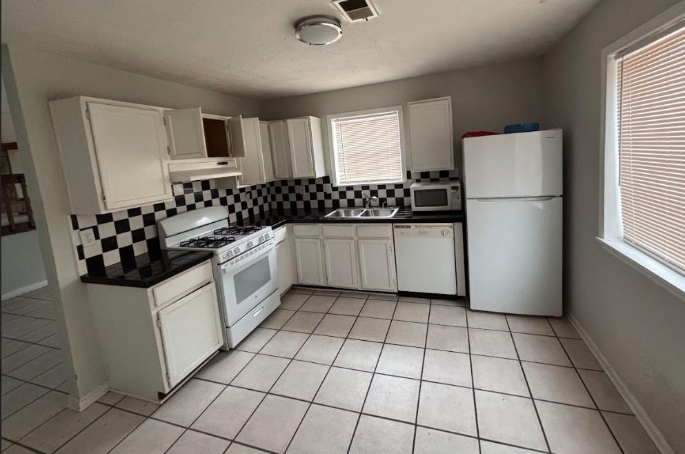 2174 Scarbrough Road Stone Mountain, GA 30088 - Photo 5 of 8 a kitchen with a refrigerator a stove a microwave and cabinets