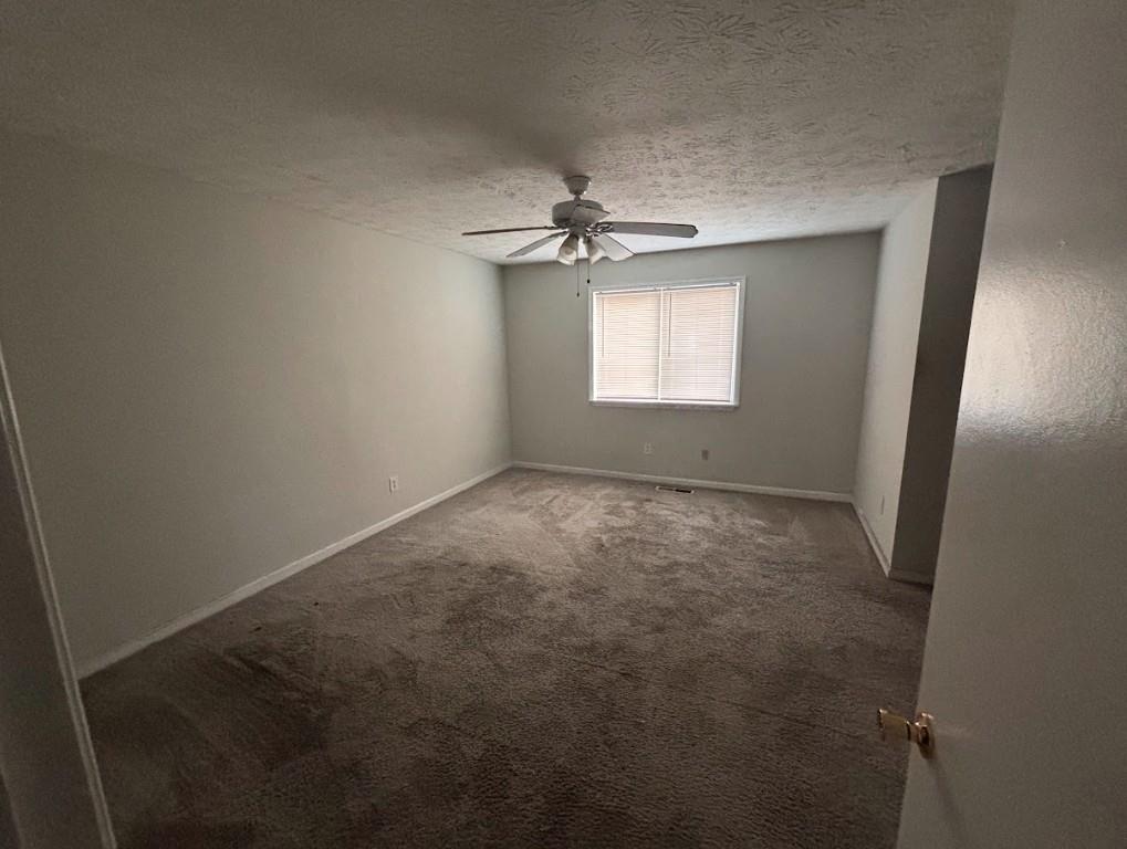 2174 Scarbrough Road Stone Mountain, GA 30088 - Photo 6 of 8 an empty room with windows and fan