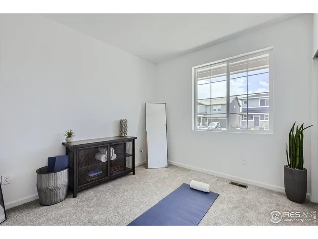 a bedroom with a bed window and chair