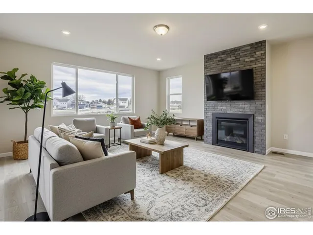 a living room with furniture potted plant a fireplace and a window