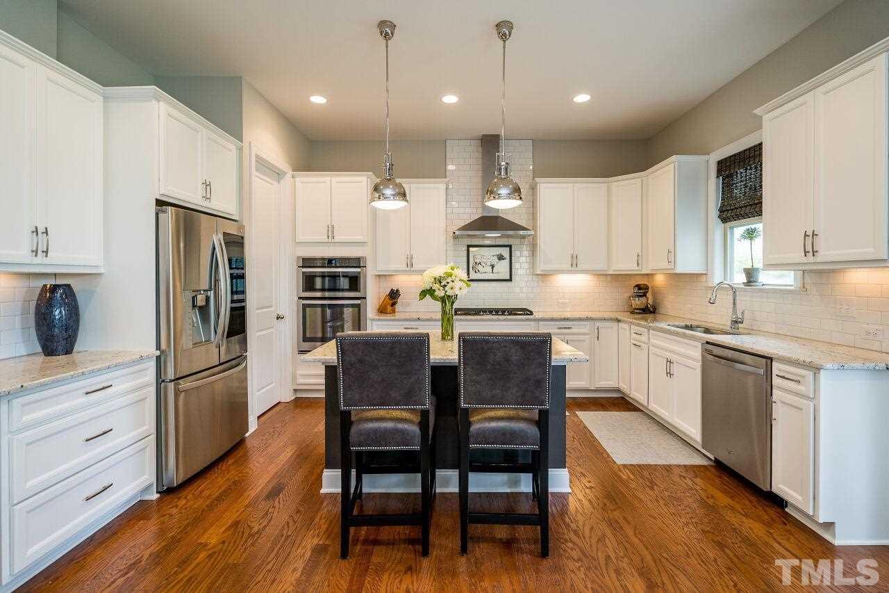 5268 Aleppo Lane Raleigh, NC 27613 - Photo 8 of 30 Quartz counters, subway tile backsplash, stainless appliances, sleek hood and kitchen island---perfect for entertaining and everyday meals!