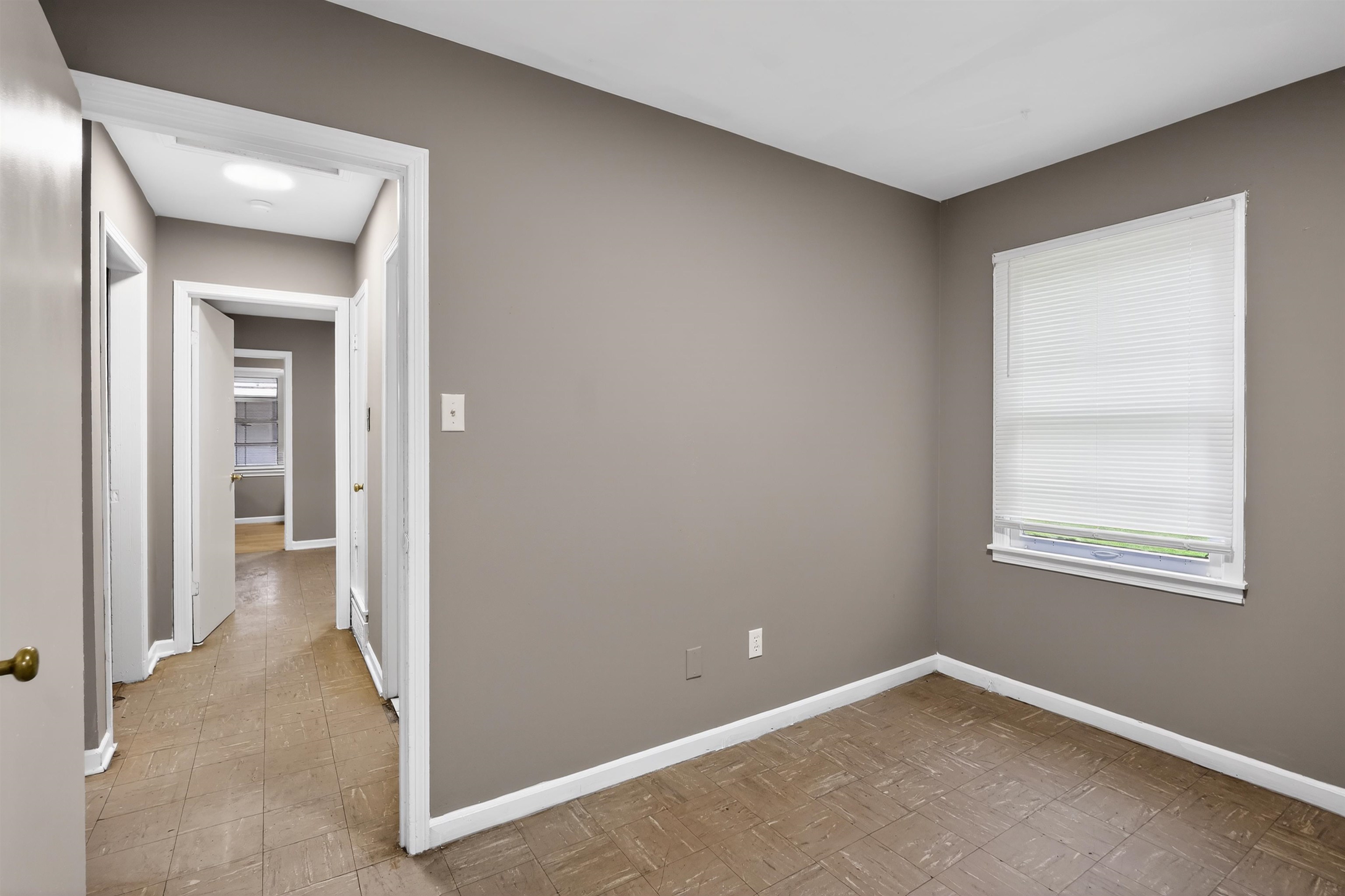 1422 Abernathy Road Memphis, TN 38116 - Photo 30 of 30 Room featuring a window with white blinds, neutral wall paint, white trim, and square tile flooring