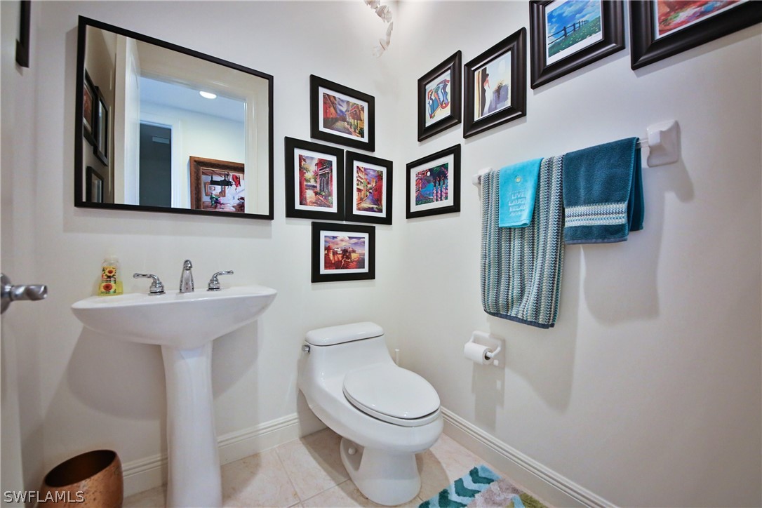 2090 West First Street, Unit 2107 Fort Myers, FL 33901 - Photo 14 of 35 a bathroom with a toilet a sink and mirror
