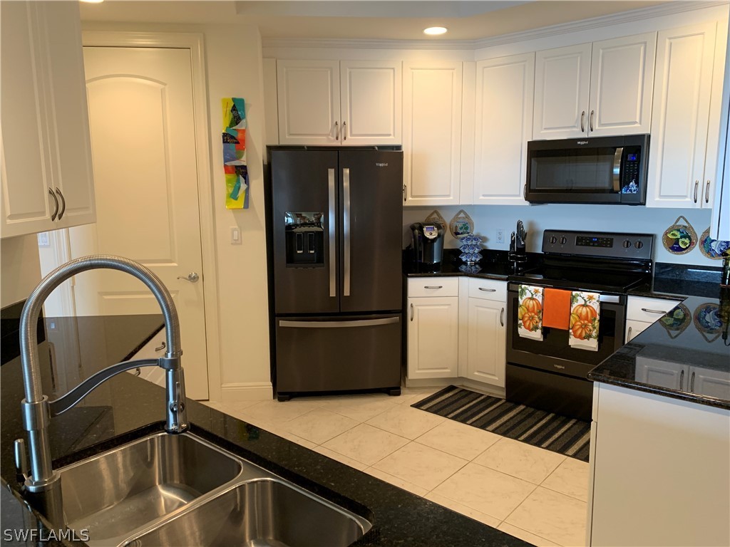 2090 West First Street, Unit 2107 Fort Myers, FL 33901 - Photo 25 of 35 a kitchen with a refrigerator and a stove top oven