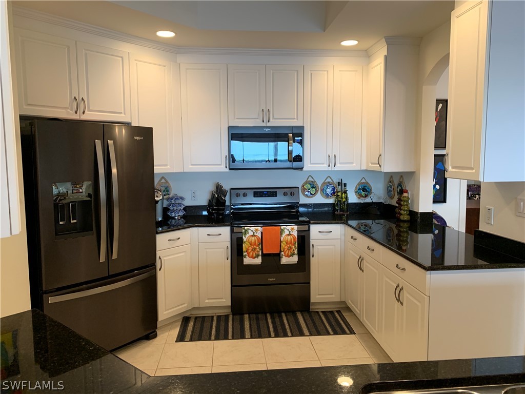 2090 West First Street, Unit 2107 Fort Myers, FL 33901 - Photo 27 of 35 a kitchen with granite countertop stainless steel appliances a refrigerator a stove a sink and a refrigerator