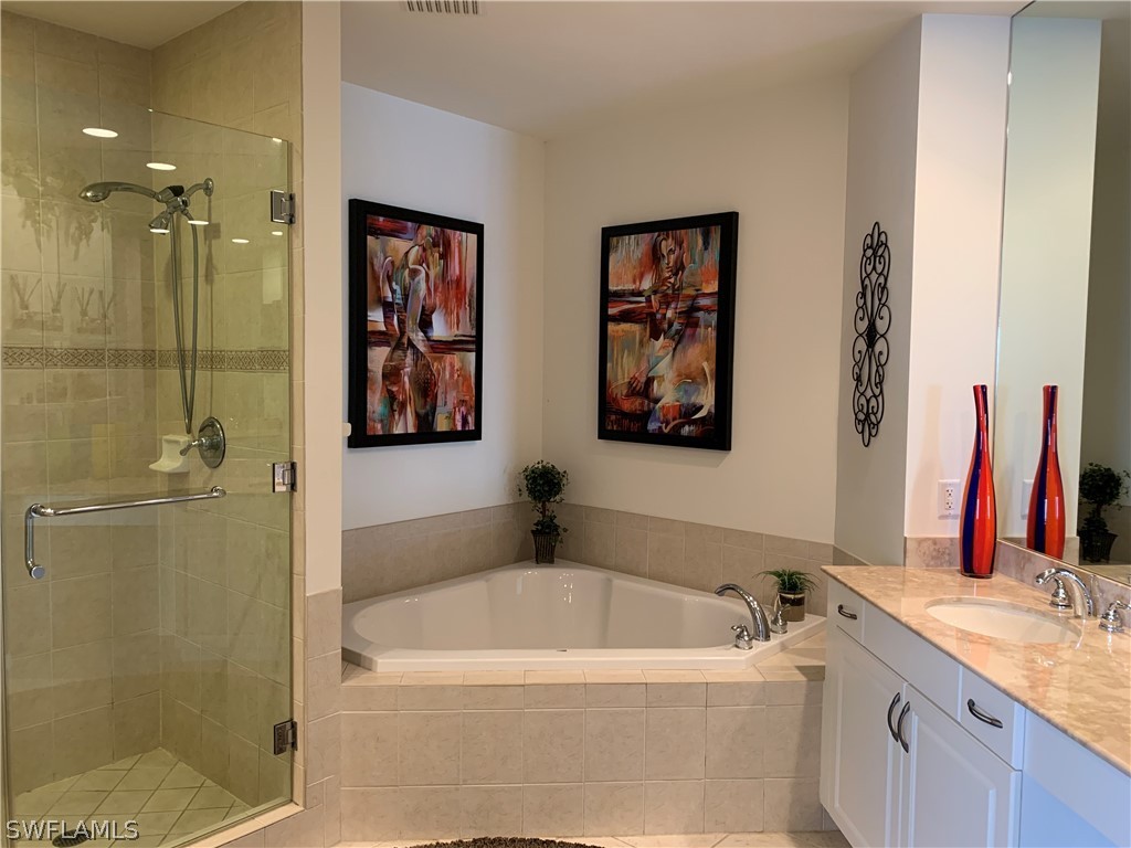 2090 West First Street, Unit 2107 Fort Myers, FL 33901 - Photo 6 of 35 a bathroom with a tub a sink and glass door
