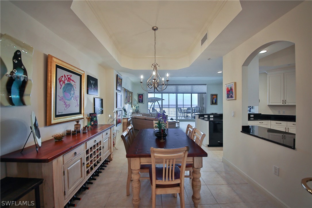 2090 West First Street, Unit 2107 Fort Myers, FL 33901 - Photo 7 of 35 a view of a dining room with furniture a chandelier and wooden floor