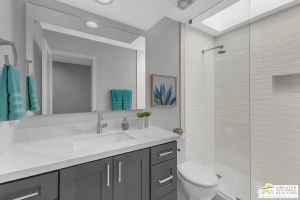 a bathroom with a granite countertop sink toilet and shower
