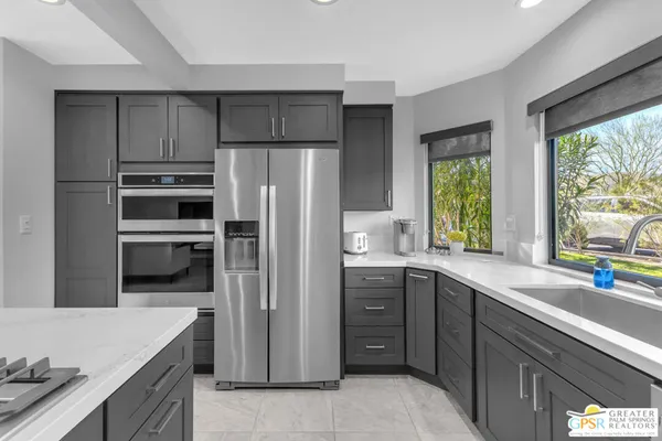 a kitchen with a sink stainless steel appliances and window