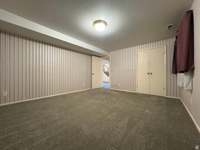 595 Meadowlark Road Orem, UT 84097 - Photo 55 of 87 Carpeted room featuring striped wallpaper, a flush-mount ceiling light fixture, and a built-in double-door closet