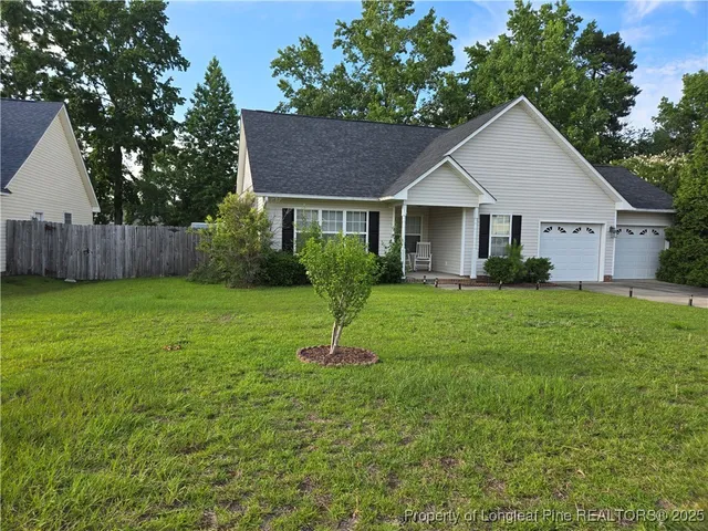 a view of a house with backyard and a tree