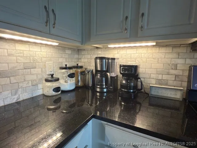 a kitchen with stainless steel appliances kitchen island granite countertop a refrigerator a stove top oven a sink with island and chairs