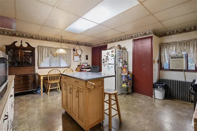 a kitchen with stainless steel appliances kitchen island granite countertop refrigerator and cabinets