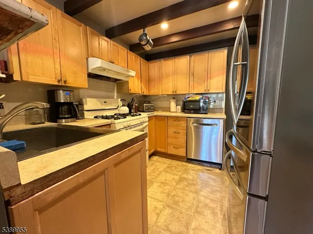 a kitchen with a sink appliances cabinets and a counter top space