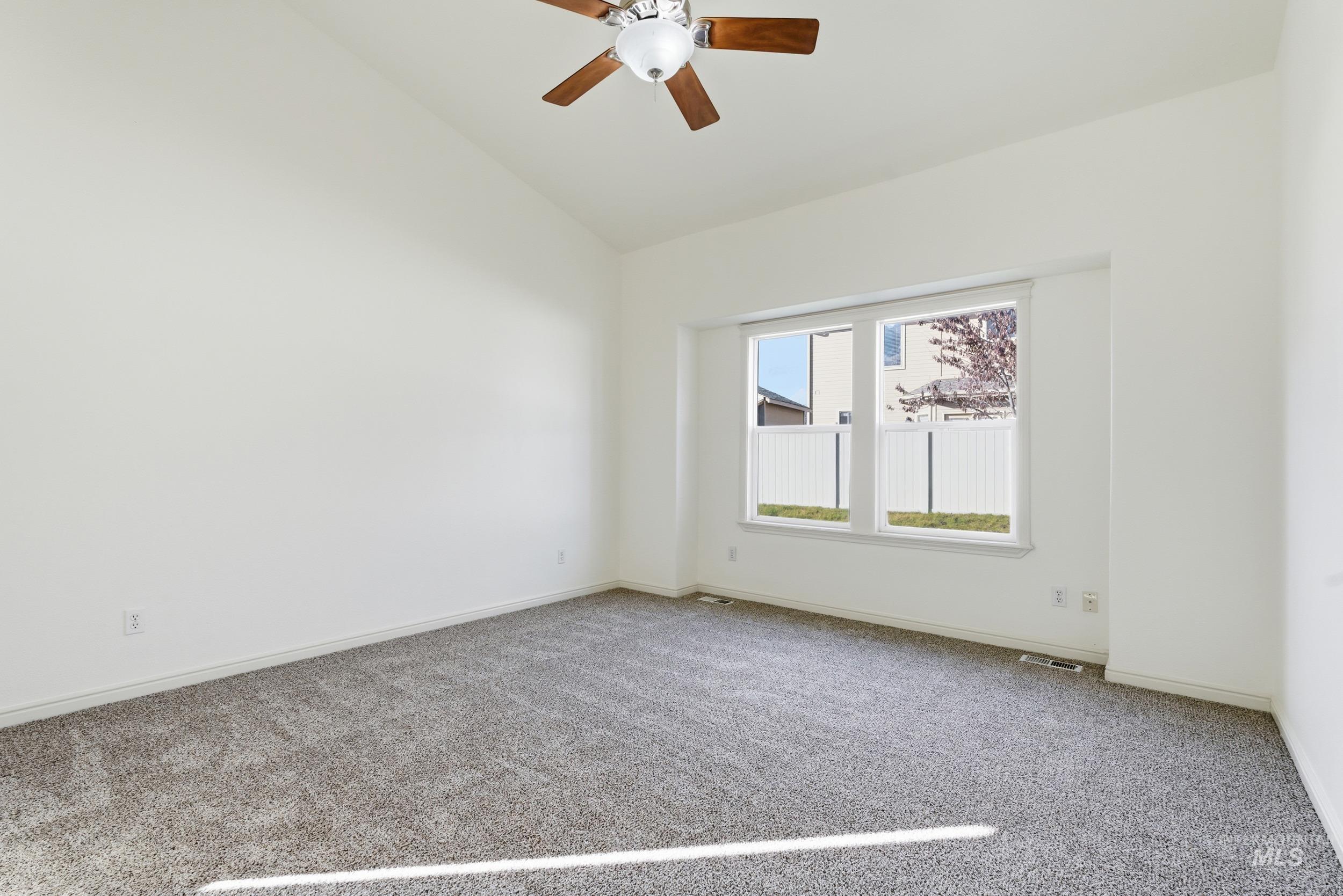1133 North Powder River Drive Middleton, ID 83644 - Photo 12 of 33 Carpeted spare room with vaulted ceiling and a ceiling fan