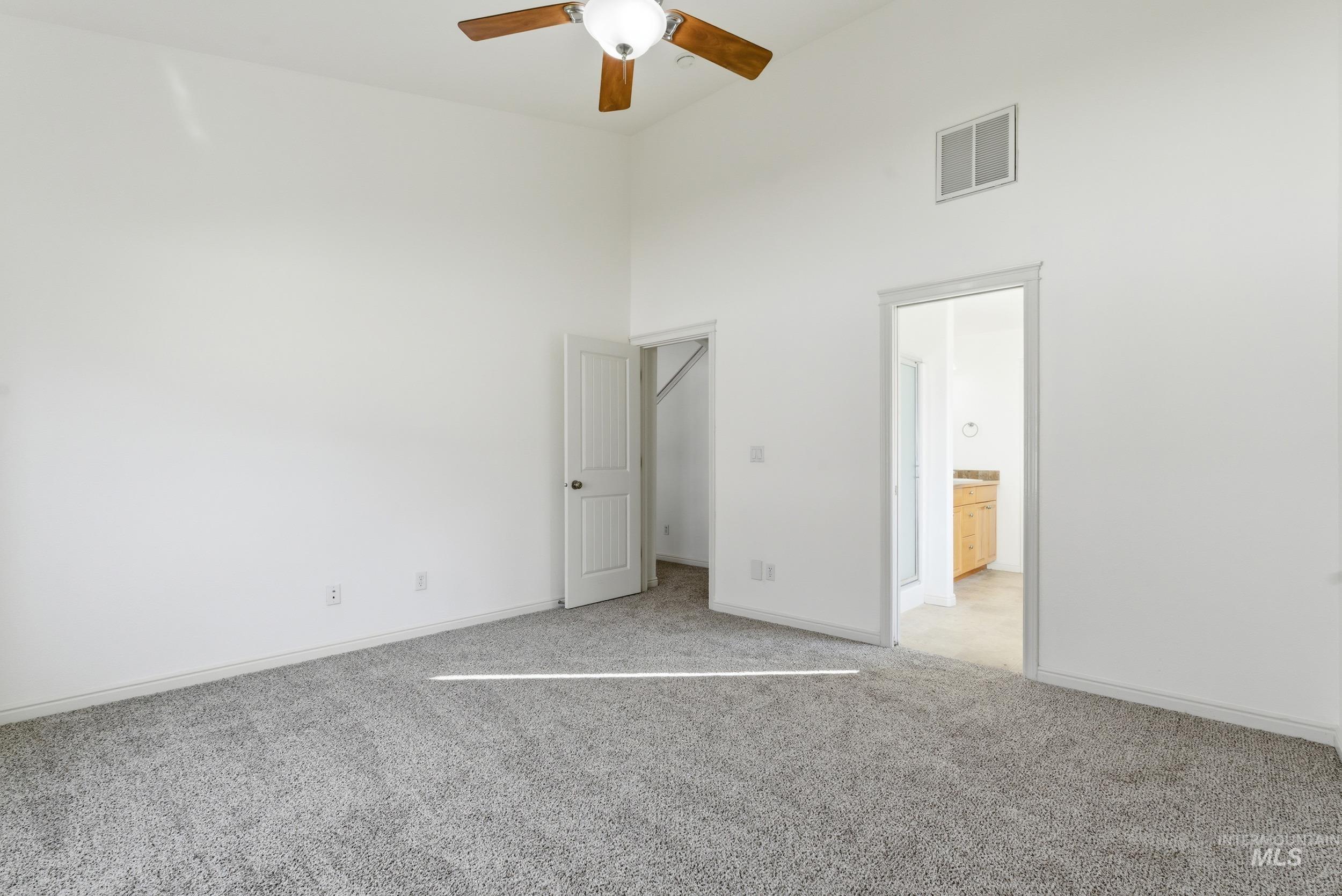 1133 North Powder River Drive Middleton, ID 83644 - Photo 14 of 33 Unfurnished bedroom with a high ceiling, light carpet, ensuite bathroom, and ceiling fan
