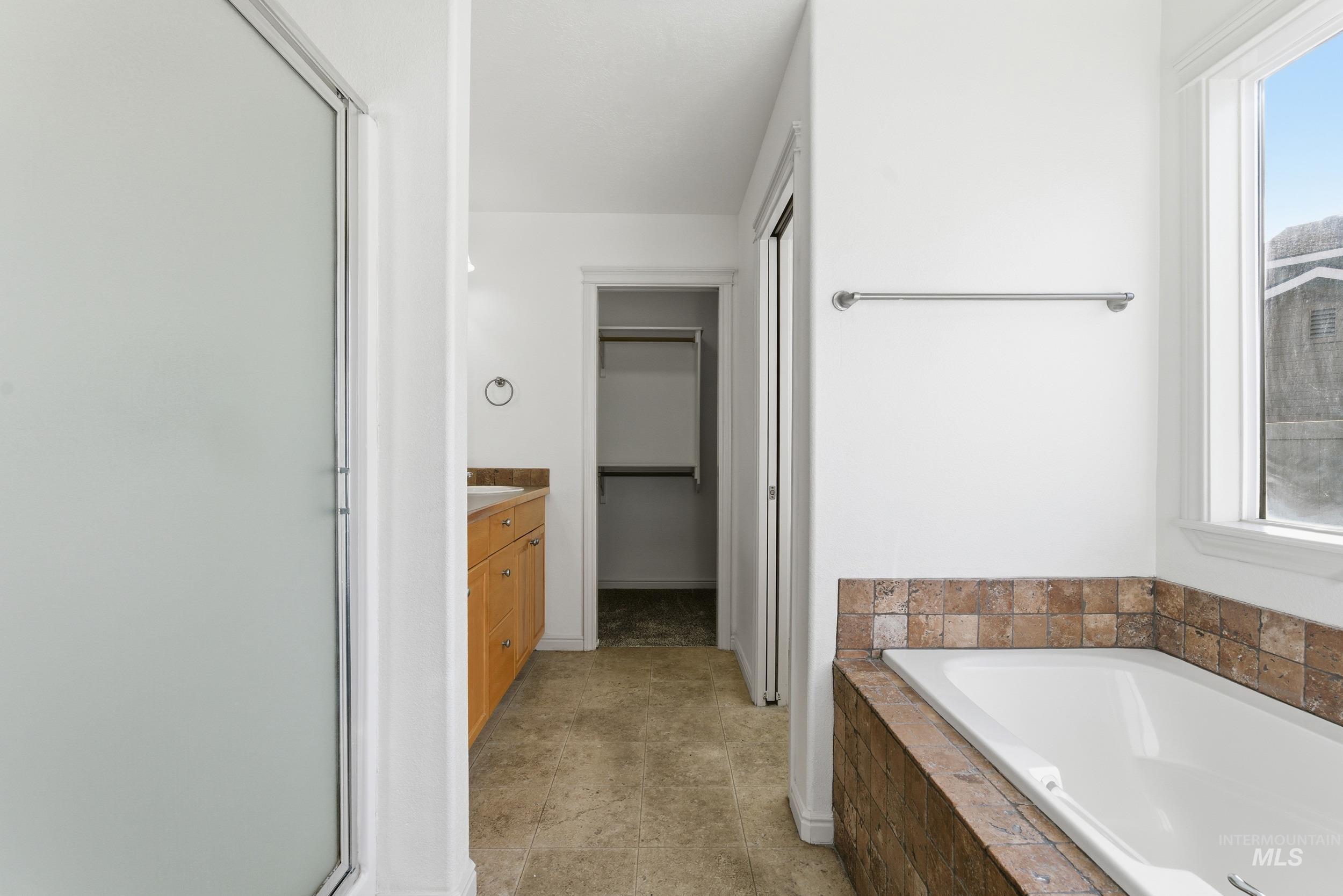 1133 North Powder River Drive Middleton, ID 83644 - Photo 15 of 33 Bathroom featuring vanity, a spacious closet, a bath, and a stall shower