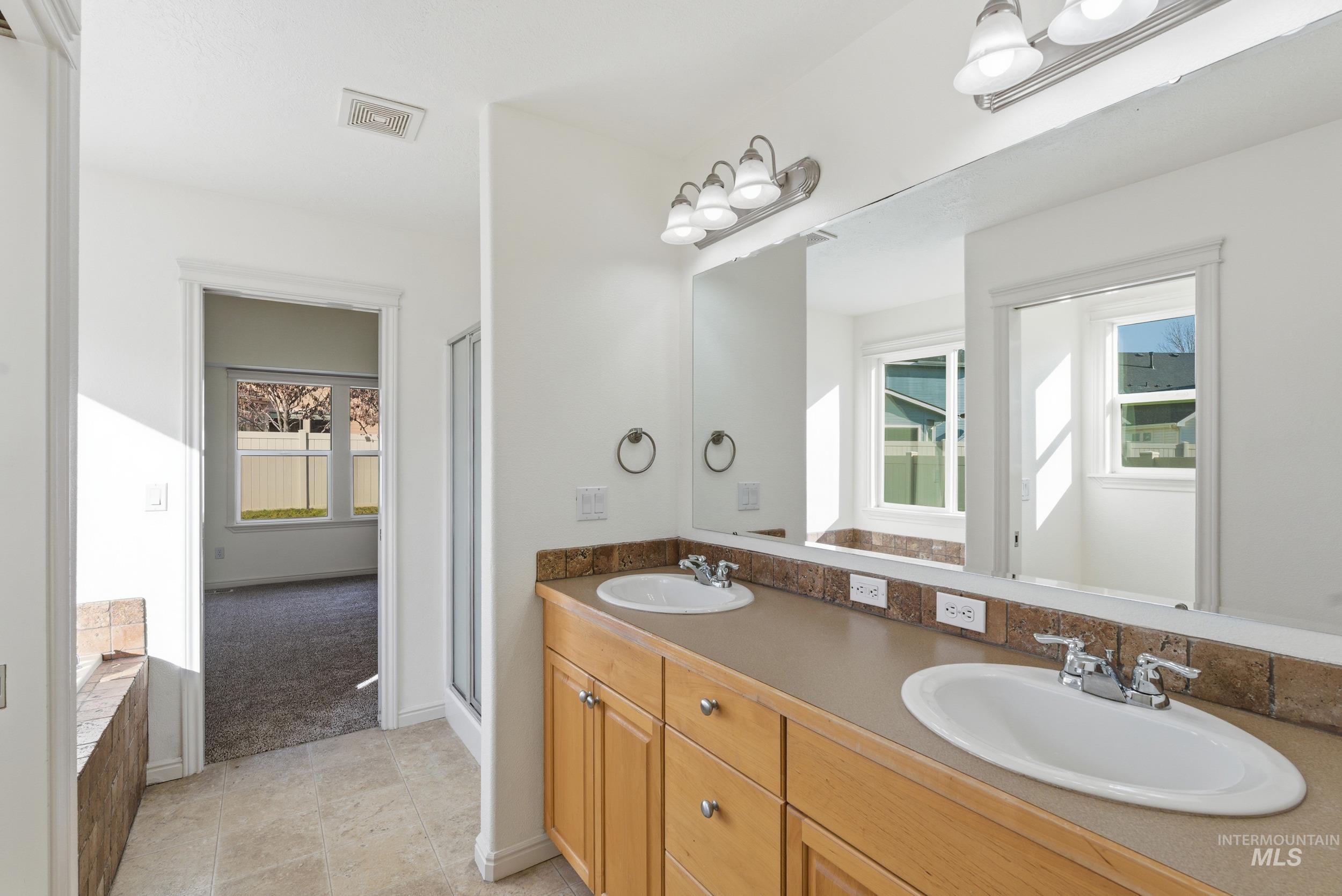 1133 North Powder River Drive Middleton, ID 83644 - Photo 18 of 33 Bathroom featuring double vanity, a stall shower, light tile patterned floors, and light carpet