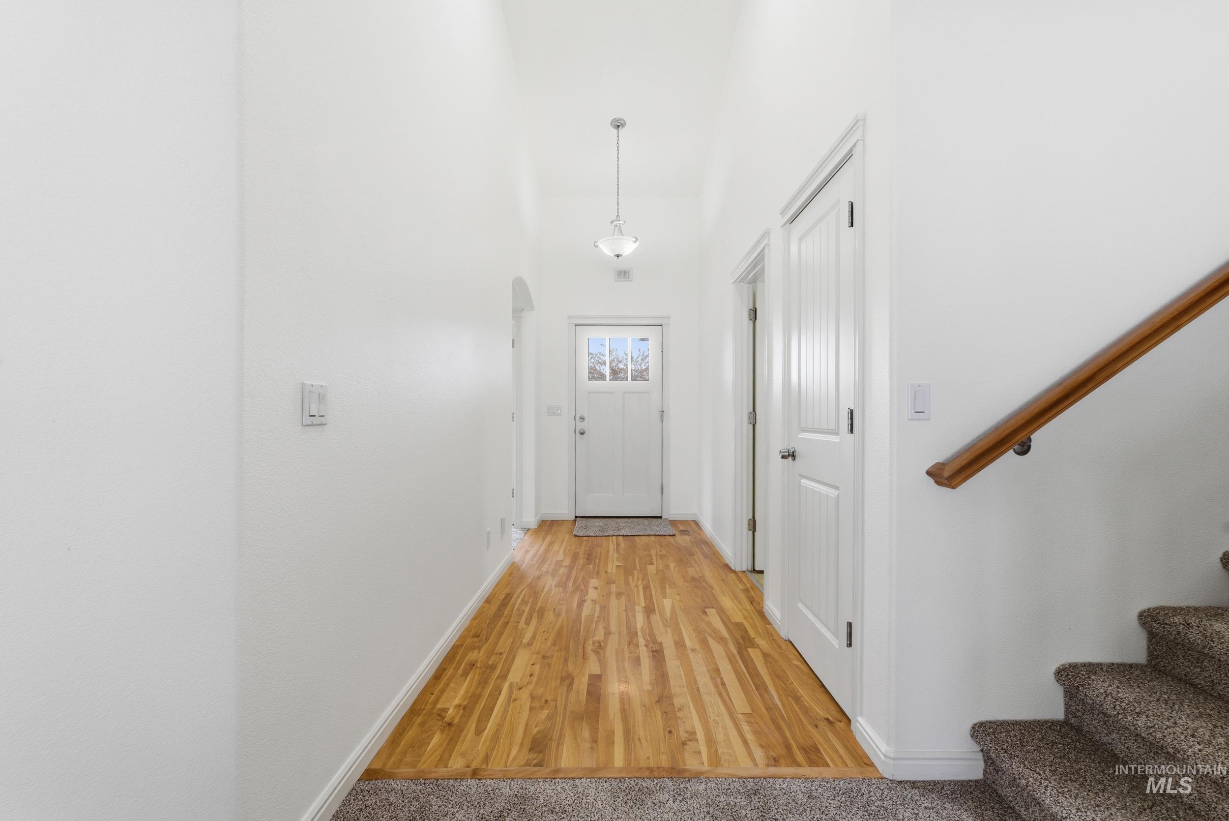1133 North Powder River Drive Middleton, ID 83644 - Photo 26 of 33 Doorway featuring wood finished floors, arched walkways, stairway, and a towering ceiling