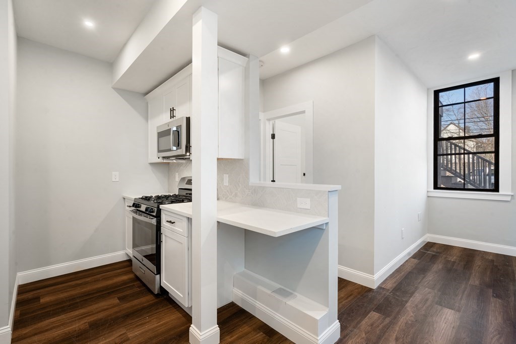 31 Monadnock Street, Unit 2 Boston, MA 02125 - Photo 5 of 11 a kitchen with granite countertop white cabinets and white appliances