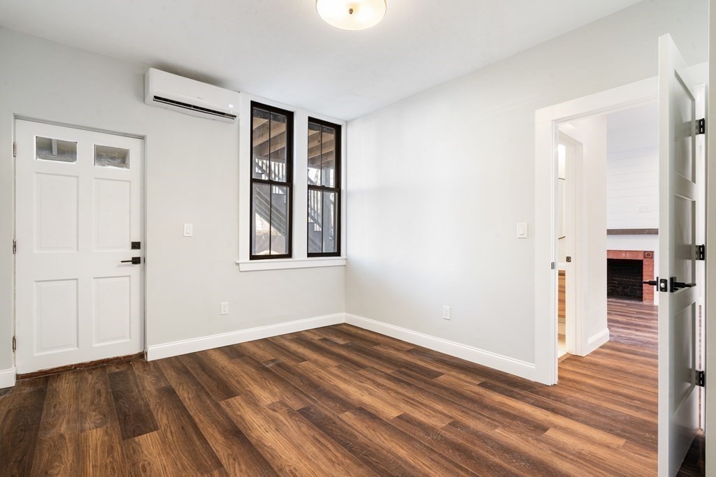 31 Monadnock Street, Unit 2 Boston, MA 02125 - Photo 7 of 11 a view of a room with wooden floor and a fireplace