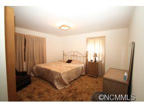 940 Hidden Valley Road Clyde, NC 28721 - Photo 11 of 23 a bedroom with a bed and a mirror
