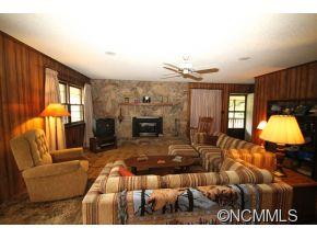 940 Hidden Valley Road Clyde, NC 28721 - Photo 6 of 23 a living room with furniture a fireplace and a flat screen tv