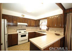 940 Hidden Valley Road Clyde, NC 28721 - Photo 8 of 23 a kitchen with kitchen island granite countertop a sink a stove and refrigerator