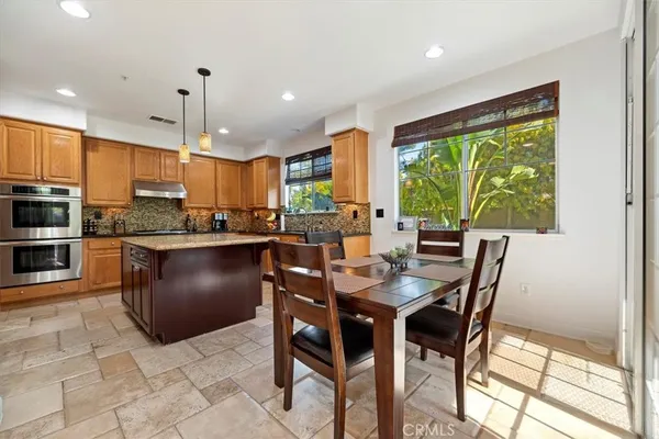 a kitchen with stainless steel appliances granite countertop a sink a stove and a refrigerator