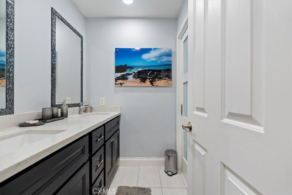 2310 Crown Point Court Oxnard, CA 93036 - Photo 27 of 50 a bathroom with a sink a mirror and a shower curtain