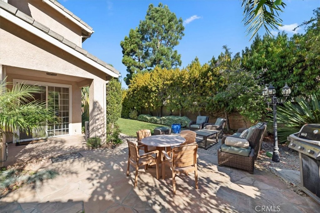 2310 Crown Point Court Oxnard, CA 93036 - Photo 38 of 50 a view of a patio with table and chairs potted plants and palm tree
