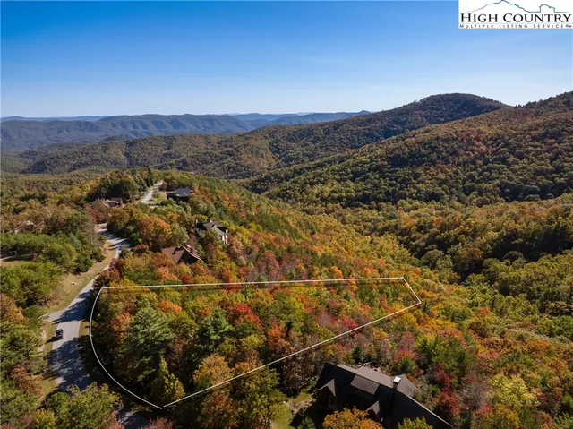an aerial view of residential house with parking and yard