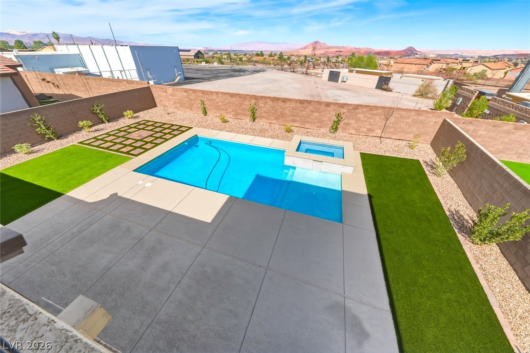 290 Rusty Ridge Lane Henderson, NV 89015 - Photo 42 of 61 Backyard w/pool & spa, desert rock w/synethic grass & pavers, built in outdoor kitchen w/fridge, cooktop & sink & No Rear Neighbors.