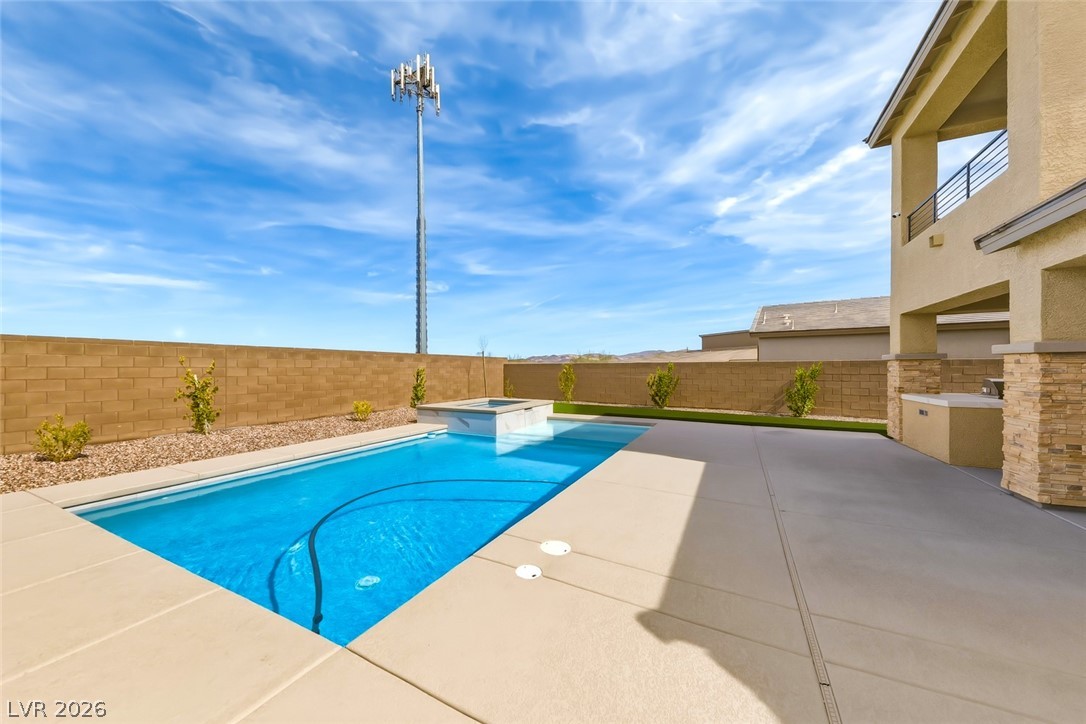 290 Rusty Ridge Lane Henderson, NV 89015 - Photo 46 of 61 Backyard w/pool & spa, desert rock w/synethic grass & pavers, built in outdoor kitchen w/fridge, cooktop & sink & No Rear Neighbors.