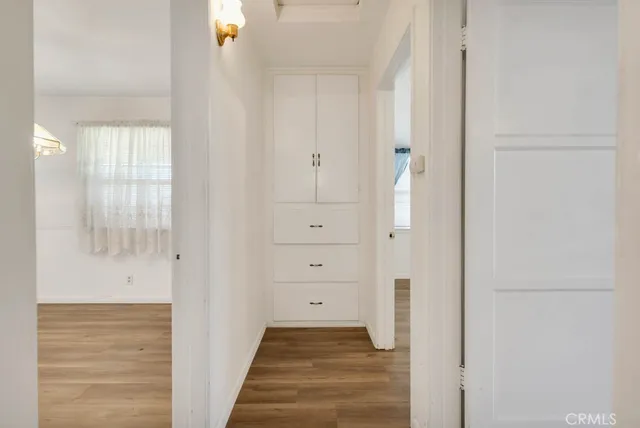 a view of a hallway with wooden floor and closet
