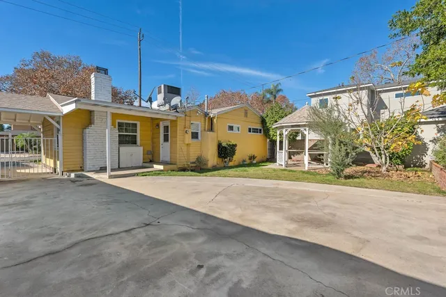 a view of a white house with a big yard and large trees