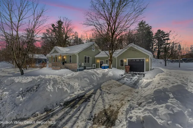 a front view of a house with a yard covered with snow in front of house