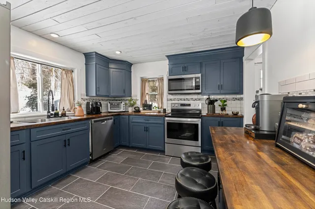 a kitchen with stainless steel appliances granite countertop a sink a stove and a refrigerator