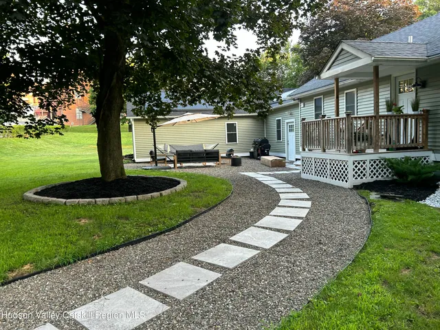 a front view of a house with a yard deck and outdoor seating