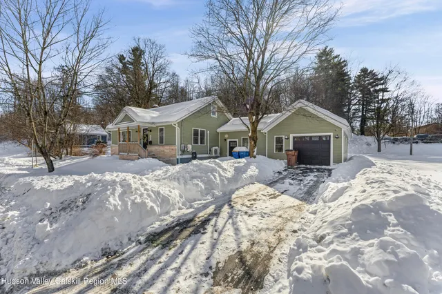 a front view of a house with a yard covered in snow