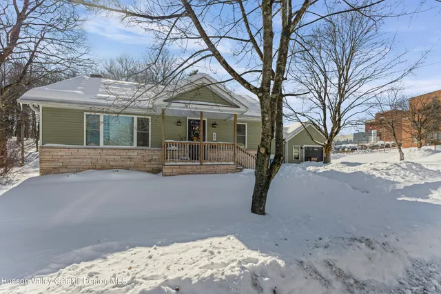 a front view of a house with a yard covered with snow
