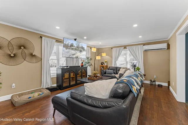 a living room with furniture and a wooden floor