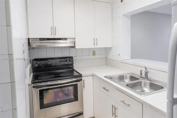 a kitchen with granite countertop white cabinets and white appliances