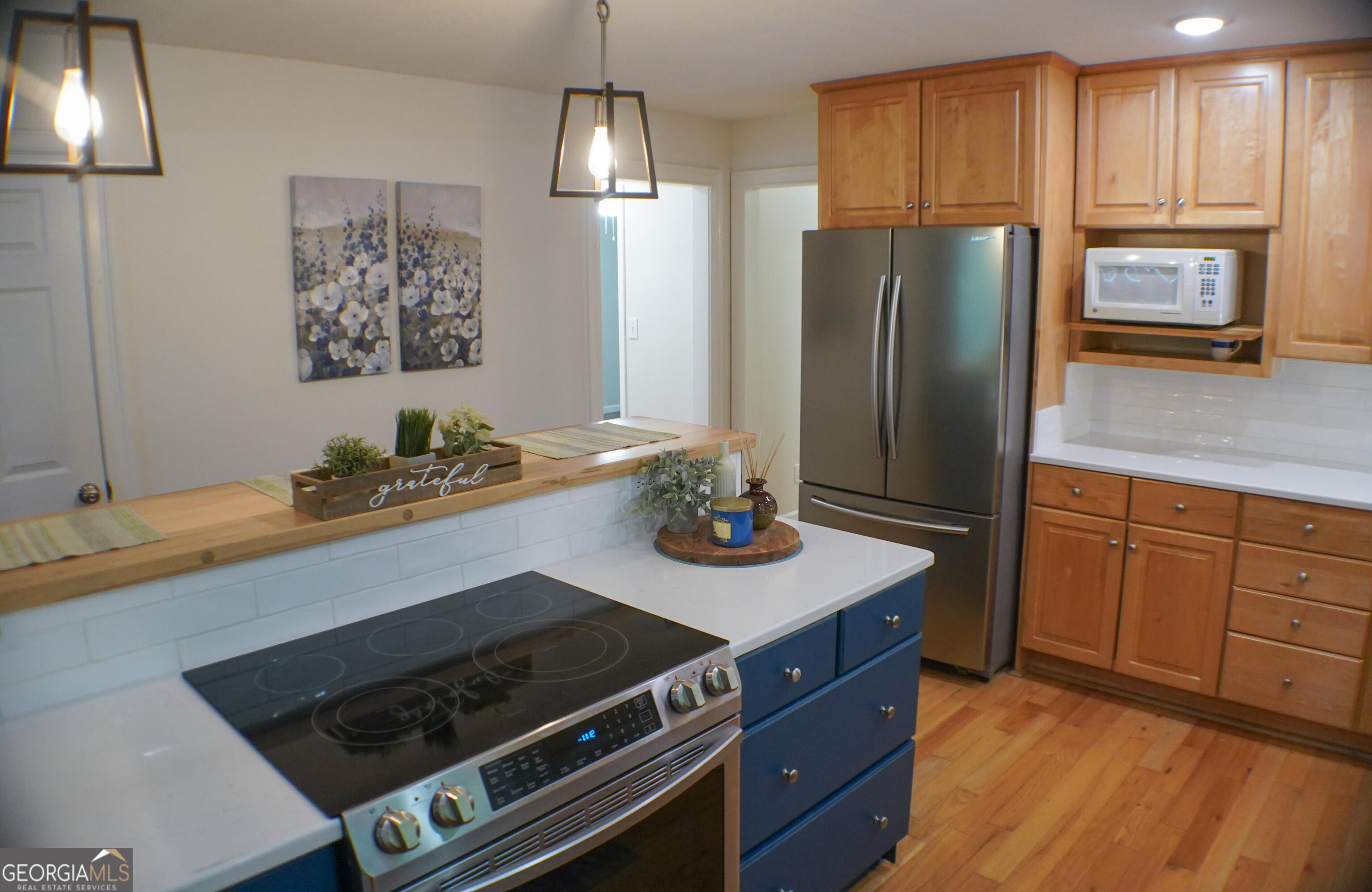 335 Winding Stream Trail Hampton, GA 30228 - Photo 11 of 35 a kitchen with stainless steel appliances granite countertop a stove refrigerator and microwave