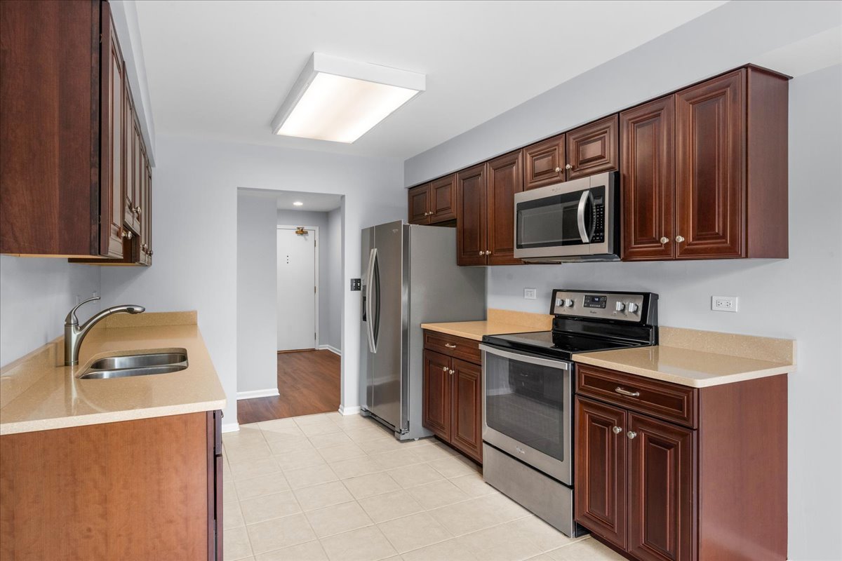 1795 Lake Cook Road, Unit 107 Highland Park, IL 60035 - Photo 11 of 26 a kitchen with stainless steel appliances granite countertop a stove a sink dishwasher a refrigerator and a microwave oven on the granite countertops